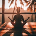 Silhouette of a woman in yoga pose at tropical sunset