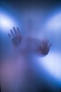 Silhouette of Womans hands behind blue Glass Royalty Free Stock Photo