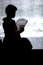 Silhouette of women with fan.