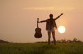 Silhouette women musician holding guitar and standing on green grass Royalty Free Stock Photo