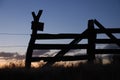 Silhouette of a wooden fence against the cool and warms colors of the setting sun