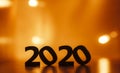 Silhouette of wooden figures of date 2020 on a glowing bright background, concept new year