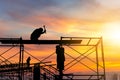 Silhouette of worker on building site, construction site at sunset in evening time