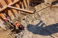 Silhouette of worker with rebar rod installing skeleton of reinforcing steel bars for bridge foundation at construction site