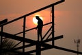 Silhouette worker welding on high  metal structure overtime work with sun set background Royalty Free Stock Photo