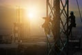 Silhouette workers on background of construction crews to work on high ground heavy industry and safety concept. Construction of Royalty Free Stock Photo