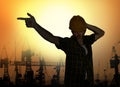 Silhouette of workman dancing happy emulating with hard hat pop star pose celebrating workday is over  on harbour cranes Royalty Free Stock Photo