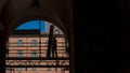 Silhouette of workman standing on scaffold in archway