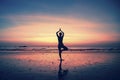 Silhouette yoga meditation girl on the background of the sea and sunset.