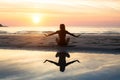 Silhouette yoga woman on the background of the sea and amazing sunset. Royalty Free Stock Photo