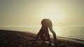 Silhouette yoga woman exercising on beach. Girl training flexibility at sunset. Royalty Free Stock Photo