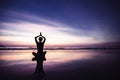 Silhouette of yoga woman in lotus position on the beach with reflection in water Royalty Free Stock Photo