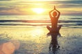 Silhouette of yoga woman meditating on the ocean beach. Fitness.