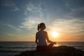 Silhouette of yoga woman meditation on the ocean beach at sunset Royalty Free Stock Photo