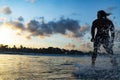 Silhouette young adult surfer rides the waves of ocean at the sundown Royalty Free Stock Photo