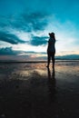 Silhouette of young asian woman standing on the beach and looking at beautiful sea and sky Royalty Free Stock Photo