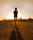 Silhouette of young attractive and fit runner woman with athletic body running on beautiful Summer sunset light training jogging w Royalty Free Stock Photo