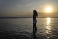 Silhouette of young beautiful asian woman standing on water free and relaxed looking at horizon on sunset beach in Bali Royalty Free Stock Photo