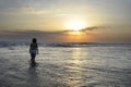 Silhouette of young beautiful asian woman standing on water free and relaxed looking at sun horizon on sunset beach Royalty Free Stock Photo