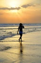 Young beautiful asian woman walking on sand sea shore free and relaxed looking at sun horizon on sunset beach Royalty Free Stock Photo