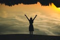 Silhouette of a young beautiful girl with hands up against the background of the sunset in the reflection of the pond Royalty Free Stock Photo