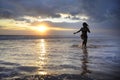 Silhouette of young beautiful and asian woman running free and happy having fun at sunset beach in Bali Royalty Free Stock Photo