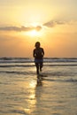 Silhouette of young beautiful and asian woman running free and happy having fun at sunset beach in Bali Royalty Free Stock Photo