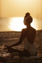 Woman in Yoga Meditation Pose with Headphones on the Beach Royalty Free Stock Photo