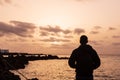 Silhouette of a young boy at sunset, looking at the sun in Lanzarote, Canary Islands