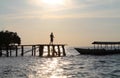 Silhouette of young boy on wooden walkway to the Bajau Village