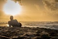 Silhouette of young caucasian male laying on Sunset Beach looking out at sunset over the ocean Royalty Free Stock Photo