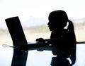 A silhouette of a young child looking on the computer. May depi Royalty Free Stock Photo