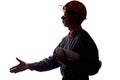 Silhouette of a young construction worker stretching out his hand for a handshake in sign of the contract, a man in overalls on a Royalty Free Stock Photo