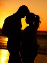 Silhouette of young couple on the beach at sunset embracing each other in affection. People on holiday, vacation and Royalty Free Stock Photo