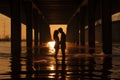 Silhouette of a young couple kissing under the bridge at sunset Royalty Free Stock Photo