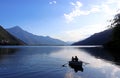 Silhouette of a young couple in a rowboat on a lake at twilight Royalty Free Stock Photo