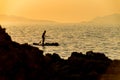 Silhouette of young couple on stand up paddle board. Active vacation, beach life