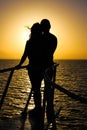 Silhouette of young couple on yacht over sea sunset. Romantic and Love concept. Royalty Free Stock Photo