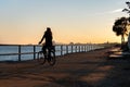 Silhouette of young curly girl riding a bicycle at the sunset on the promenade road of Maresme, Catalonia, Spain Royalty Free Stock Photo