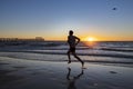 Silhouette young dynamic athlete runner man with fit strong body training on Summer sunset beach running barefoot in sport healthy Royalty Free Stock Photo