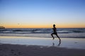 Silhouette young dynamic athlete runner man with fit strong body training on Summer sunset beach running barefoot in sport healthy Royalty Free Stock Photo