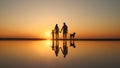 Silhouette of a young family with dog with reflection on the lake or sea coast Royalty Free Stock Photo