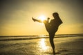 Silhouette of young fit Muslim woman covered in Islam hijab head scarf training martial arts karate kick attack and fitness