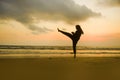 Silhouette of young fit Muslim woman covered in Islam hijab head scarf training martial arts karate kick attack and fitness