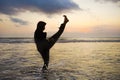 Silhouette of young fit Muslim woman covered in Islam hijab head scarf training martial arts karate kick attack and fitness Royalty Free Stock Photo