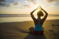 Silhouette of young fit sport woman in beach sunset yoga practice in meditation doing heart shape with hands and fingers against t Royalty Free Stock Photo