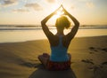 Silhouette of young fit sport woman in beach sunset yoga practice in meditation doing heart shape with hands and fingers against t Royalty Free Stock Photo