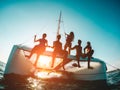 Silhouette of young friends chilling in private catamaran boat - Group of people making tour ocean trip - Alternative travel Royalty Free Stock Photo