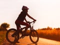 Silhouette of young girl on a bicycle at sunset Royalty Free Stock Photo