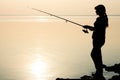 Silhouette of a young girl fishing at sunset Royalty Free Stock Photo